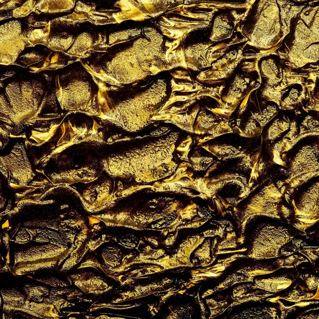 Feuille d’or froissée en gros plan, aux reflets profonds.